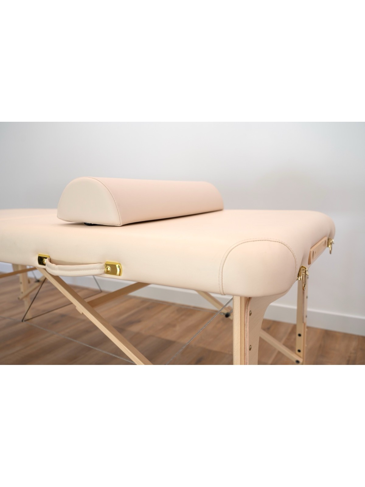 Coussin demi-cylindre beige pour table de massage, offrant un soutien ergonomique pour le cou et les jambes.