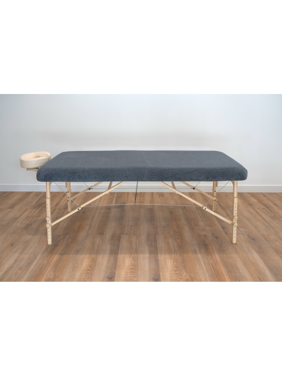 Table de massage équipée d'une housse anthracite, apportant une touche élégante et professionnelle.